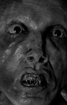 a close up of a man 's face with a very scary expression