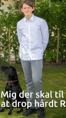 a man standing next to a black dog with the words mig der skal til at drop hardt r