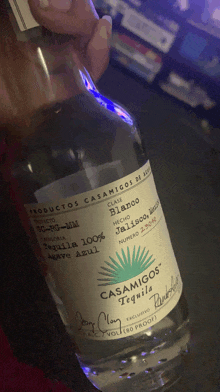 a bottle of casamigos tequila is being held by someone