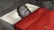 a man is laying in a bed with a red blanket and a white pillow .