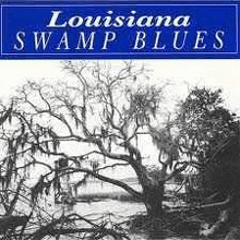 a black and white photo of a tree next to a body of water on the cover of louisiana swamp blues .