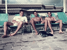 three men are sitting in chairs with one wearing a shirt that says ' coca cola '