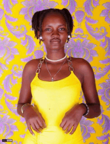 a woman wearing a yellow top and a pearl necklace