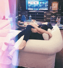 a woman laying on a bean bag chair with a tv in the background