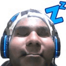 a man wearing headphones and a bandana on his head with a zzz sticker on his head .