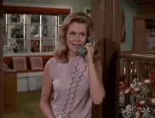 a woman is talking on a telephone in a room .