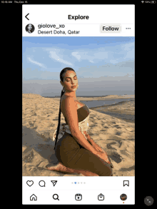 a woman in a green dress is kneeling on a sandy beach