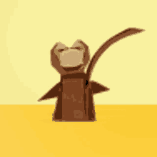 an origami monkey with a long tail is standing on a yellow table .