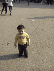 a little boy wearing a yellow shirt that says ' a ' on it