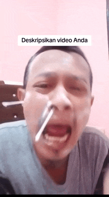 a man with a spoon sticking out of his nose with the words deskripsikan video anda on the bottom right