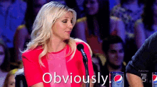 a woman in a red dress is sitting in front of a microphone and says obviously