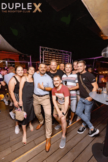 a group of people are posing for a photo at the duplex rooftop club