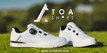 a pair of white toa shoes sitting on a grassy field