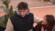 a man and a woman are hugging with the words star academy in live behind them
