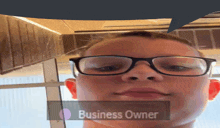 a boy wearing glasses has a speech bubble above his face that says business owner