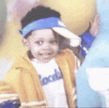 a young boy wearing a yellow jacket and a blue headband .