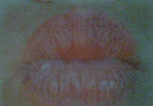 a close up of a person 's lips with a red spot on the bottom .