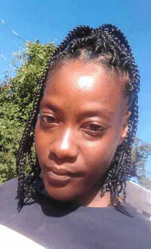 a close up of a woman 's face with braids in her hair