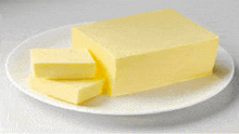 a white plate topped with a block of butter and two slices of butter