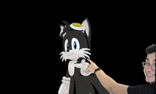 a man pointing at a black and white cat