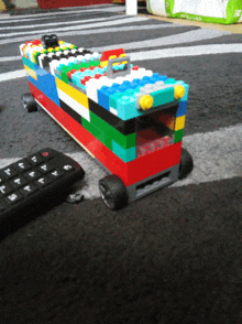 a remote control sits next to a toy made out of lego