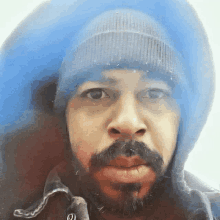 a man with a beard wearing a beanie and hoodie