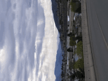 a view of a city from the side of a highway with mountains in the background