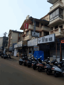 a row of scooters are parked in front of a building that says tattoo hub