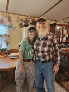 a man and a woman are posing for a picture and the woman is wearing a green shirt that says " i love my country "