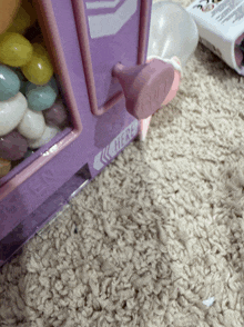 a pink and purple gumball machine with the word here on the side