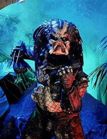 a predator is standing in a jungle holding a sword