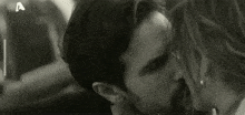 a man and woman are kissing in a black and white photo with the letter a in the corner