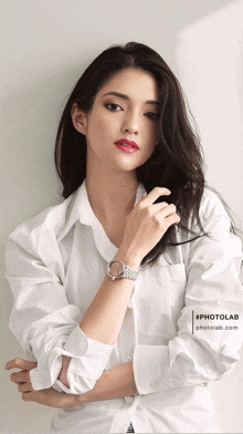 a woman wearing a white shirt and a watch with the photolab logo on the bottom right