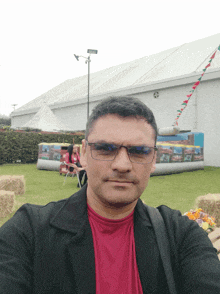 a man taking a selfie in front of a large white tent