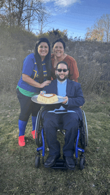 a man in a wheelchair is holding a plate with a birthday cake on it