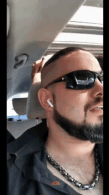 a man with a beard wearing sunglasses and earbuds