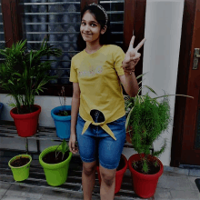 a girl wearing a yellow shirt that says ' i love you ' giving a peace sign