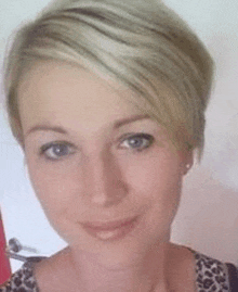 a close up of a woman 's face with short hair and a leopard print shirt .