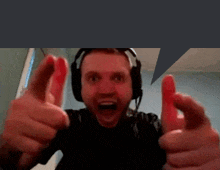 a man wearing headphones is giving two thumbs up