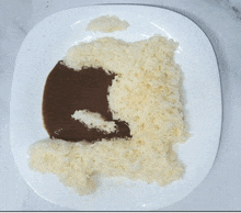 a white plate topped with rice and brown sauce that looks like a cat