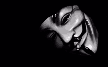 a black and white photo of a v for vendetta mask in the dark