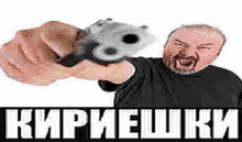 a man with a beard is pointing a gun at the camera with a foreign language on the bottom .