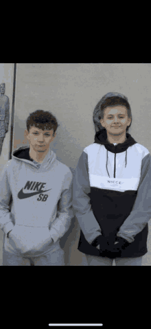 two boys standing next to each other one wearing a grey nike sb hoodie