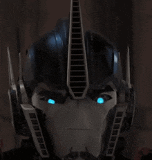 a close up of a robot 's helmet with blue eyes