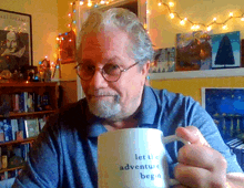 a man is holding a coffee mug that says let the adventure begin