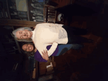 a woman in a white sweater stands next to a woman in a purple shirt