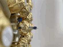 a close up of a gold colored item with a blue connector