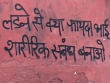 a red wall with black writing in a foreign language on it