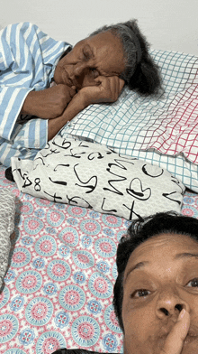 a woman laying on a bed with a pillow that says x on it