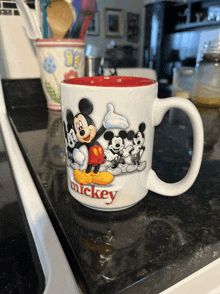 a mickey mouse mug sits on a counter